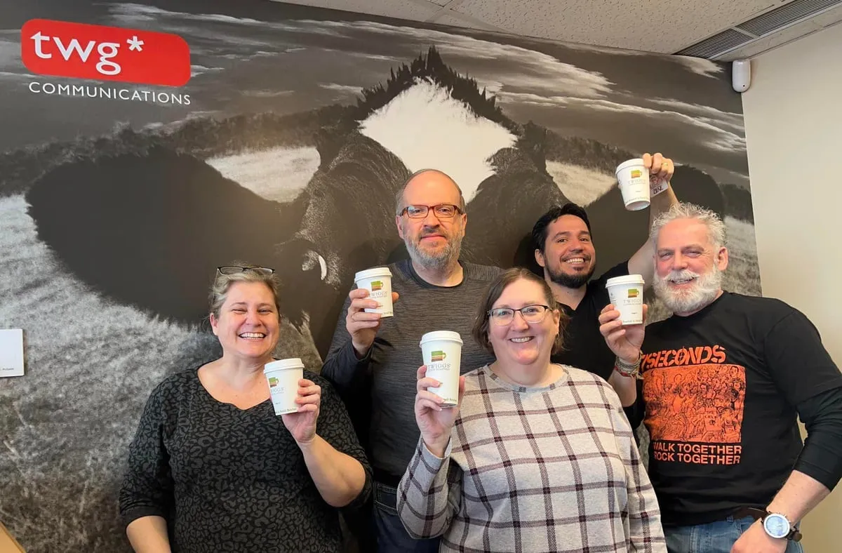 Team members raising NoahStrong coffee cups