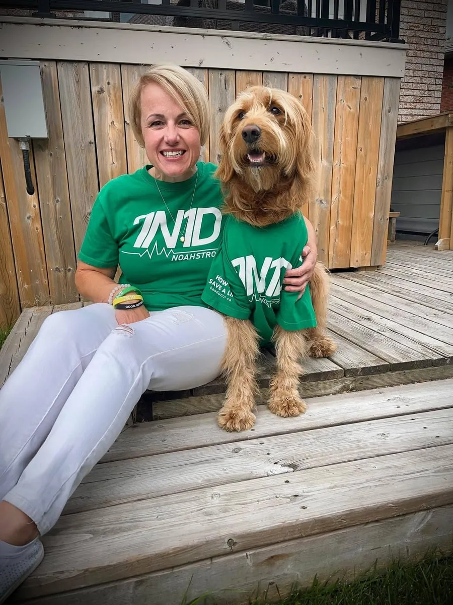 Woman and her dog both wearing green 7N1D shirts