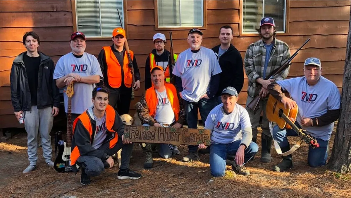 Hunters at a cabin wearing NoahStrong merch