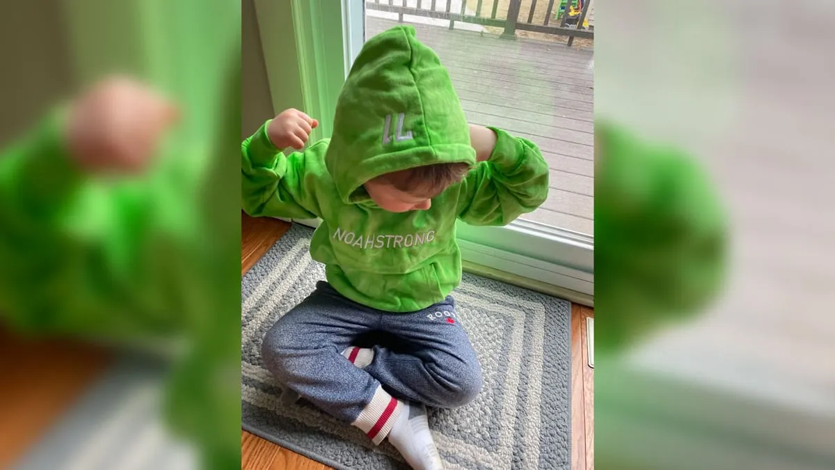 Child in a green NoahStrong tie-dye hoodie